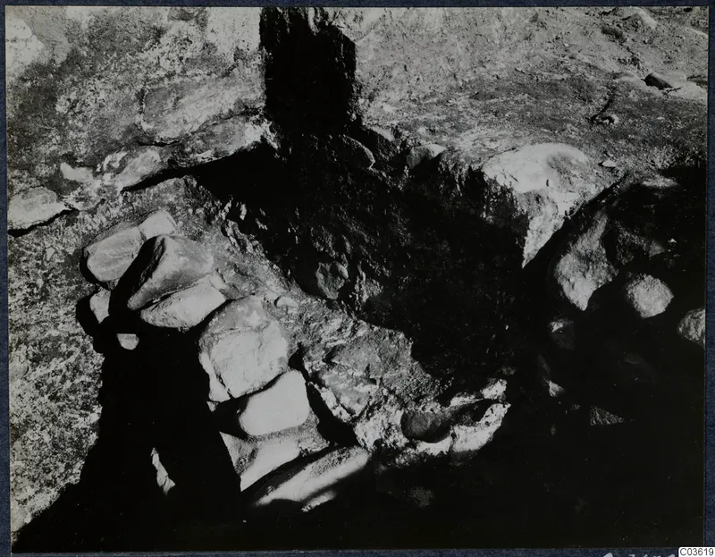 Excavation at Soli, Cholades temples: a stone construction of large blocks set against cut rock and dark soil.