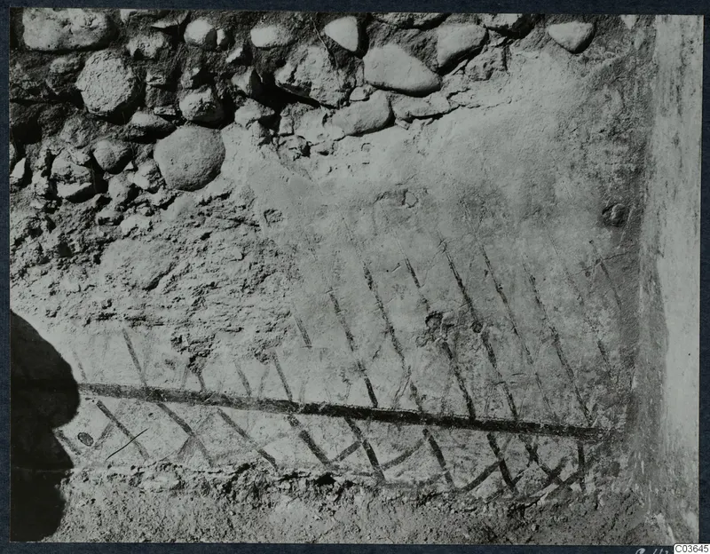 Room X at Soli, Cholades: painted diagonal lines on a plastered wall, with rough stone masonry above