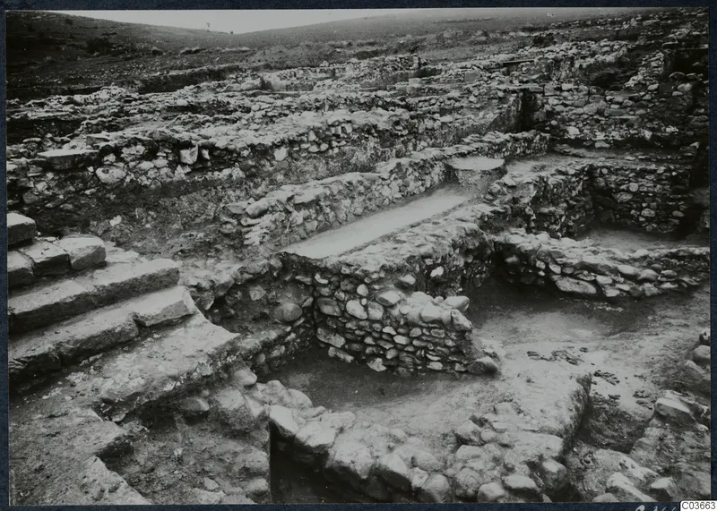 Excavated stone walls and a flight of cut stone steps at Soli, with the ruins of the Cholades temples across the site.