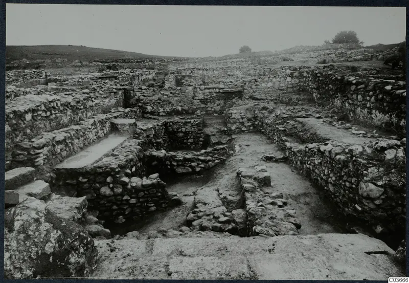 Excavated stone walls and foundations at Soli, Cholades temples, seen across a dug area with low hills behind