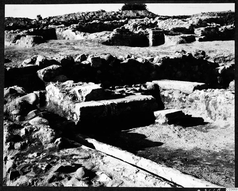 Excavated ruins at the Cholades temples A-B at Soli, with stone walls, large blocks and a stone channel in the foreground.