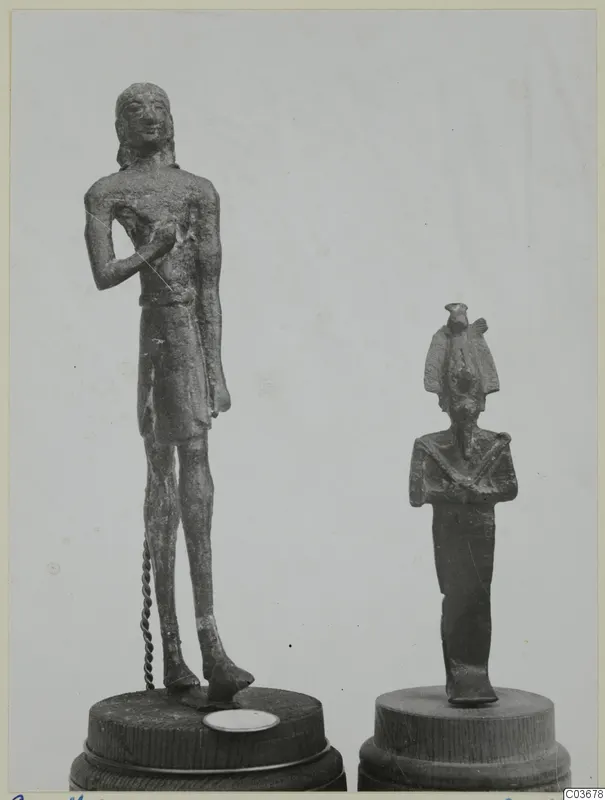 Two small bronze figures on wooden bases: a standing male figure at left and a smaller figure in a tall headdress at right.