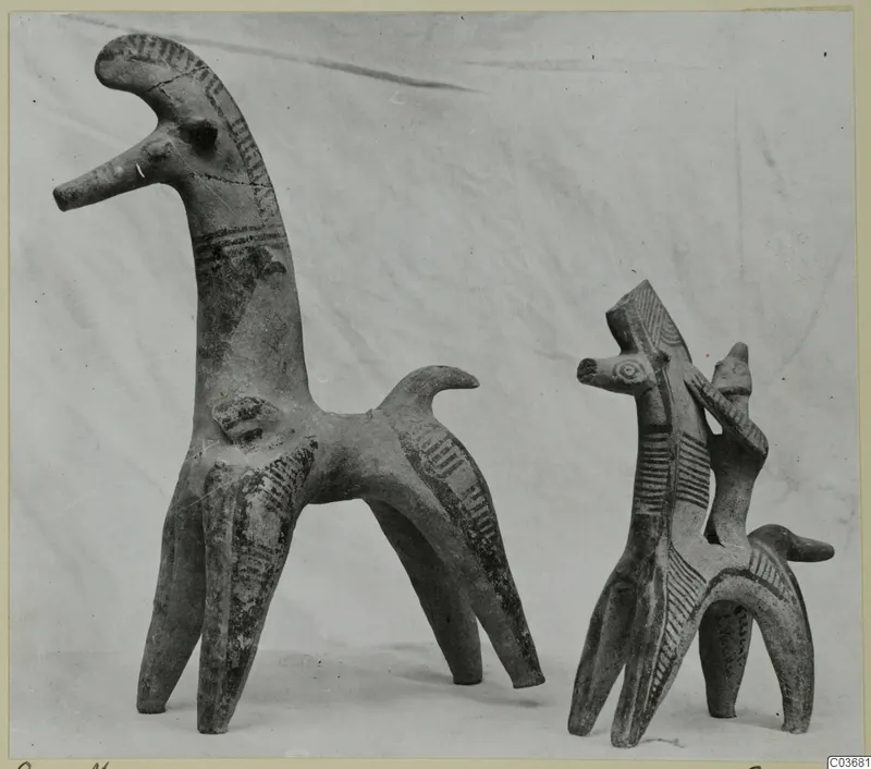 Two terracotta animal figurines with dark painted stripes on their necks, bodies and legs.