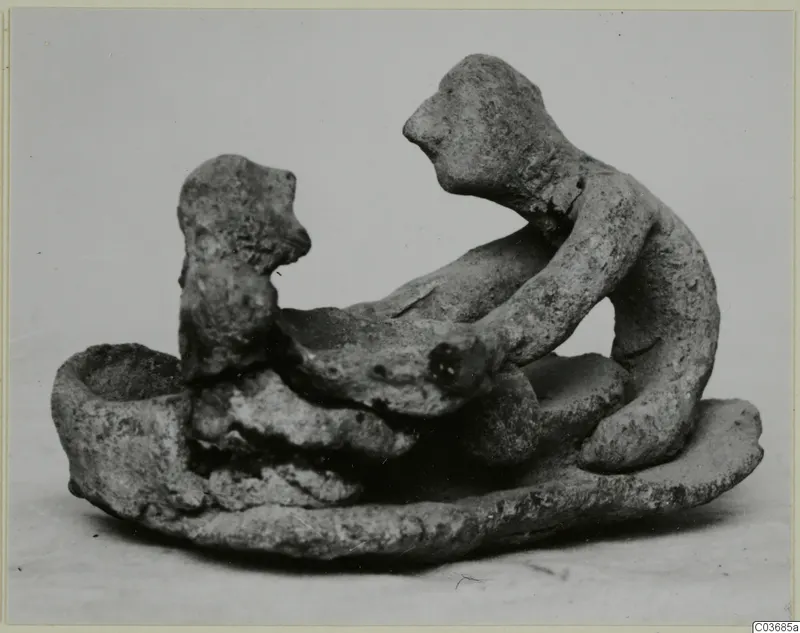 Terracotta group of two small figures on an oval base, beside a cup-shaped hollow.