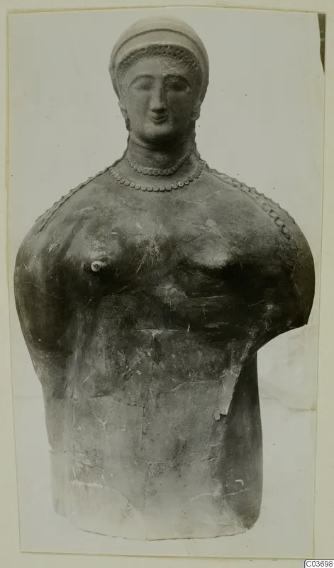Bust of a woman with a cap-like headdress and beaded necklace, seen frontally against a pale background, from Vouni