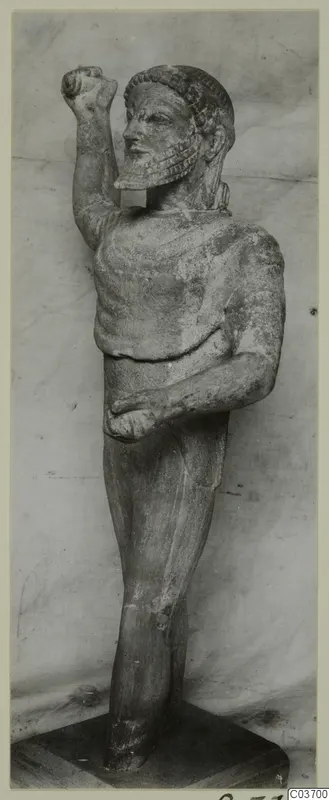Limestone statue of a bearded standing male figure from Kition, one fist raised beside the head
