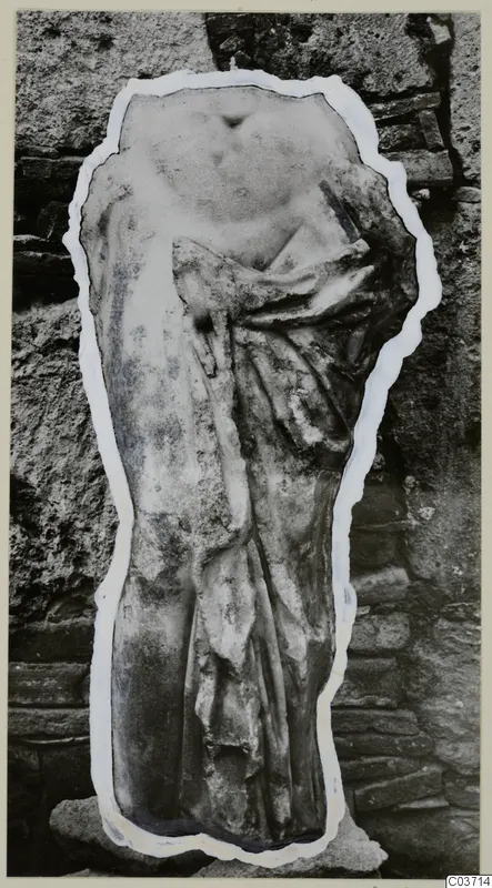 Marble sculpture fragment of a draped torso, cut out and mounted on a card against a stone wall