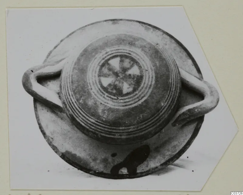Vessel with two loop handles seen from above, with concentric rings and a radiating pattern on its top
