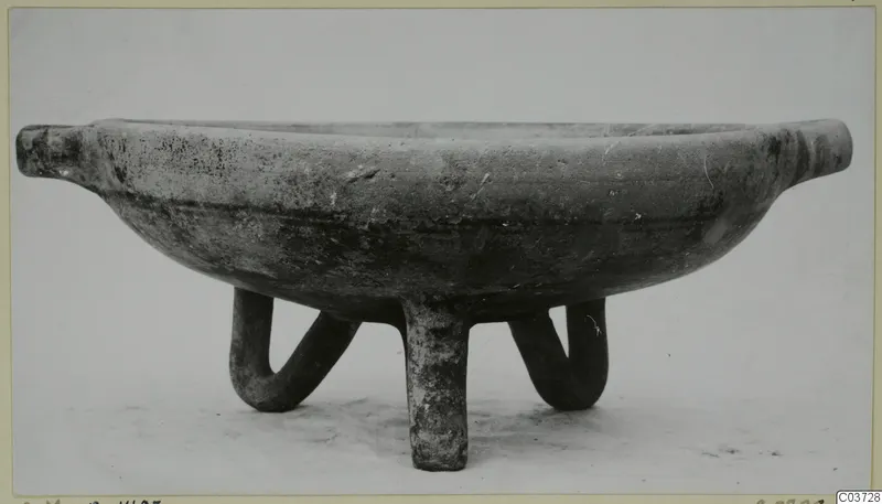 Pottery White Painted III-1 bowl on three tubular legs, with a small horizontal lug at each side of the rim.