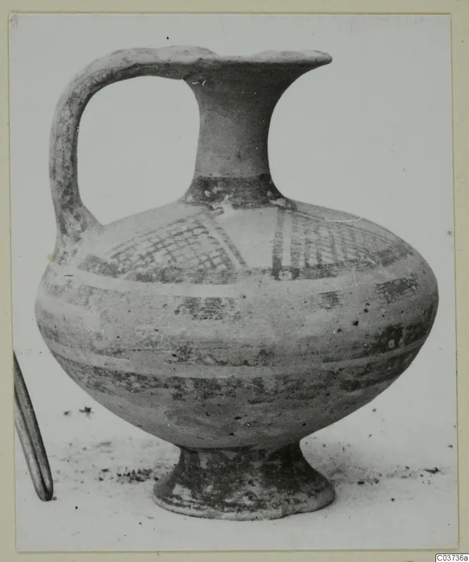 White Painted I jug with a strap handle, cross-hatched panel and painted bands, standing on a pale surface.
