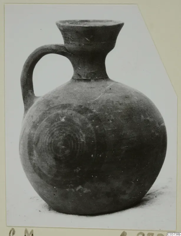 White Painted I jug with a strap handle and concentric circles on its round body