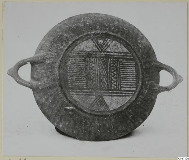 Round shallow vessel with two loop handles, its central panel decorated with bands of horizontal lines, zigzags and cross-hatching
