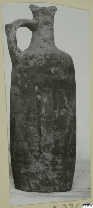 Single-handled pottery vessel with a tall neck, photographed on a mounted card