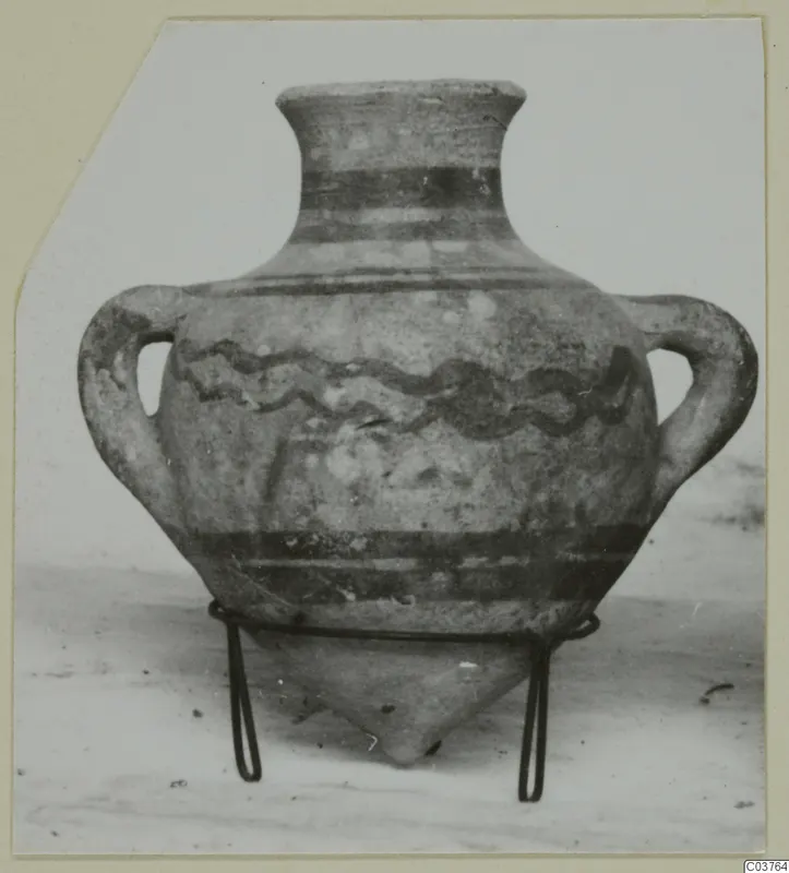 Two-handled pottery amphora with wavy and banded painted decoration, standing on a wire stand