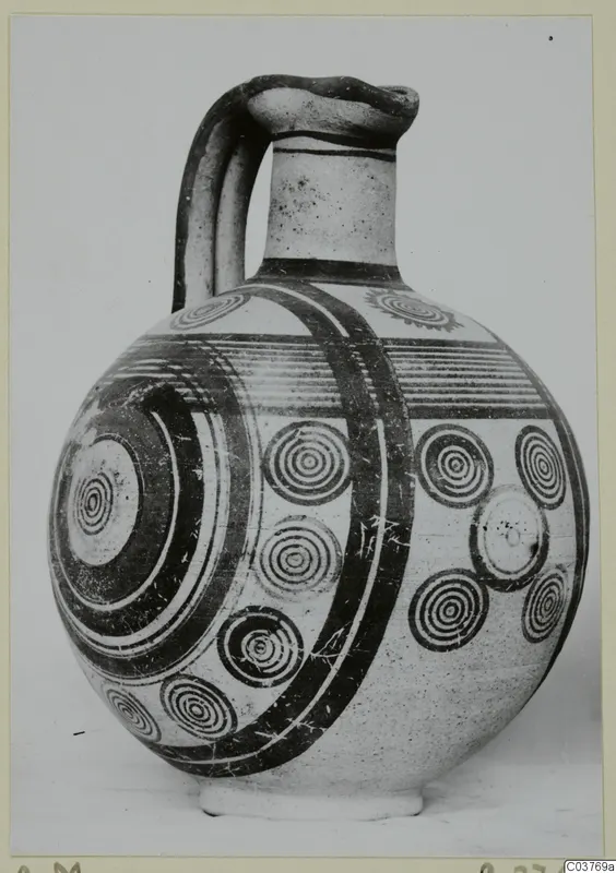 Bichrome IV jug with a strap handle and dark concentric-circle painting, in three-quarter view