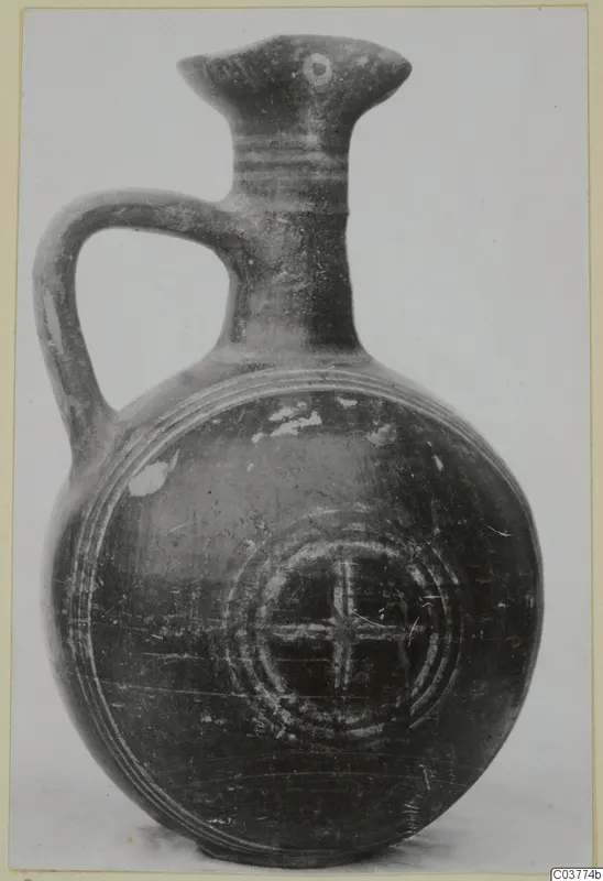 Round-bodied jug with a strap handle and flared spout, decorated with concentric rings and a cross-in-circle motif.