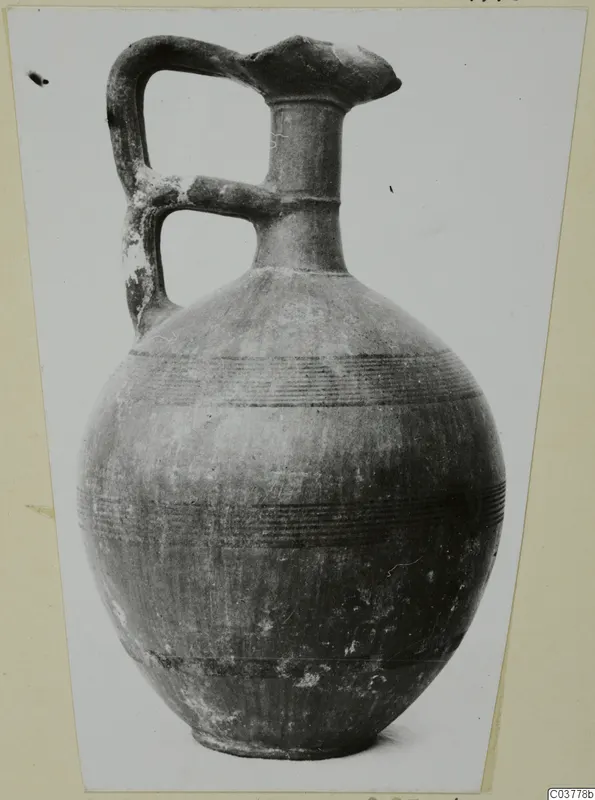 Round-bodied jug with a strap handle and horizontal bands of lines, recorded as Black-on-Red I-III