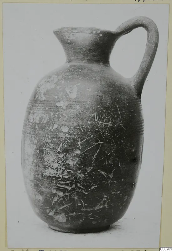 Single-handled jug with a high neck and rounded body, photographed against a plain background.