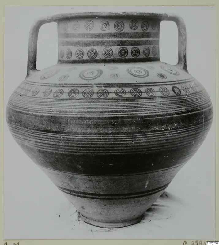 Two-handled painted pottery jar with bands of concentric circles and horizontal stripes, photographed against a plain background.