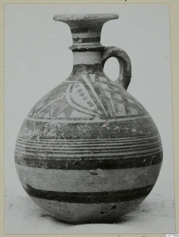 Jug with a flared rim, loop handle and painted bands, with a panel of curved and dotted motifs on the shoulder