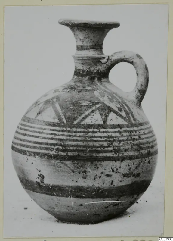 Pottery Bichrome IV jug with a flared rim, single handle, and painted bands and triangles