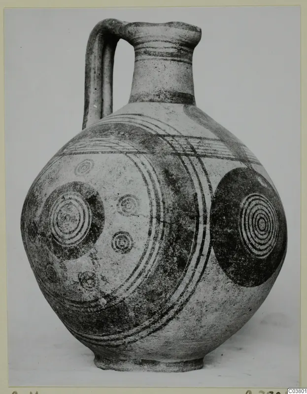 Jug with a strap handle and dark concentric circles and bands painted on its body