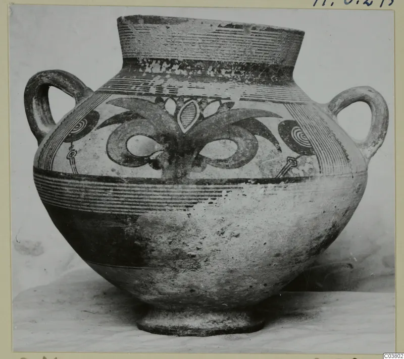 Two-handled painted pottery jug with a tall flaring neck and bands of linear and spiral decoration.