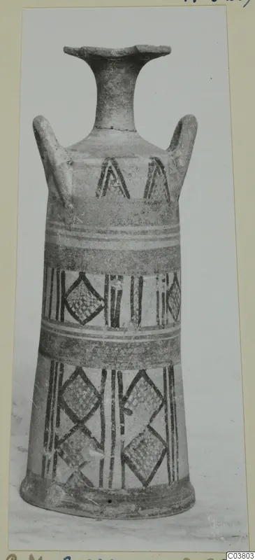 Painted pottery vessel with a flaring rim, two handles, and bands of lozenges, triangles and vertical stripes, photographed upright.