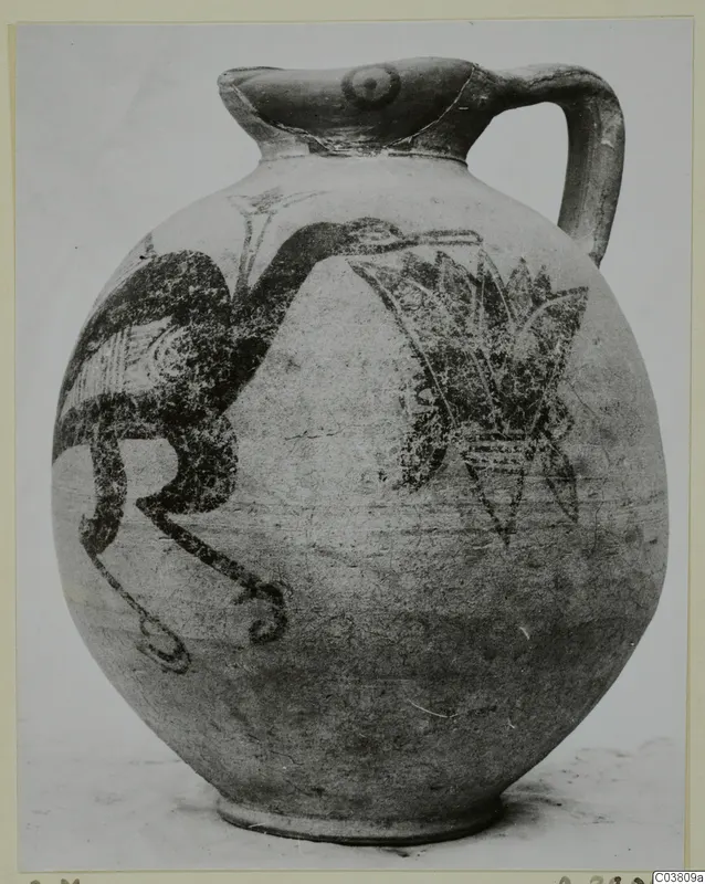 Bichrome IV jug with a painted bird and a spray of leaves, photographed on a light card mount