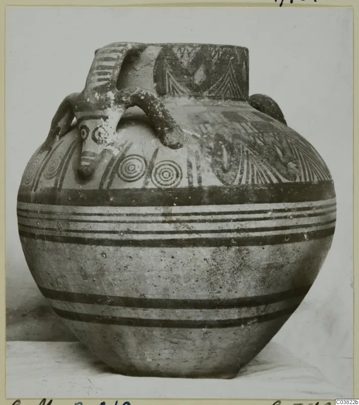 Bichrome IV jug with painted bands, concentric circles and a modelled face beside one of its handles