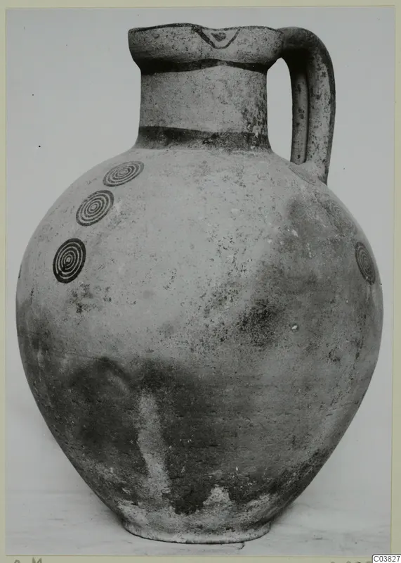 Pottery White Painted IV jug with a single loop handle and dark concentric circle motifs on the shoulder