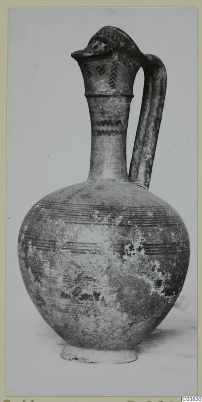 Pottery Bichrome III jug with a globular body, tall neck and loop handle, painted with bands and motifs