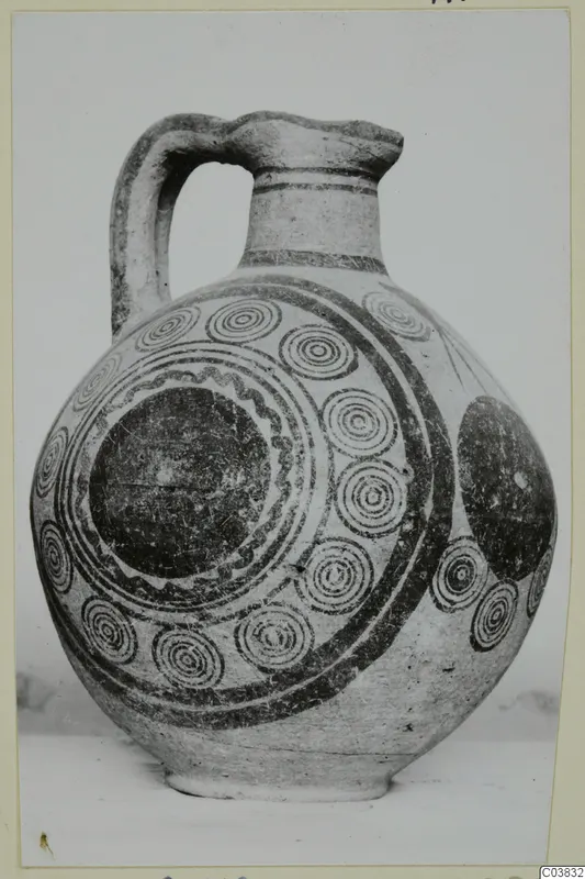 Bichrome IV jug with a strap handle, its pale body painted with dark concentric circles and bands