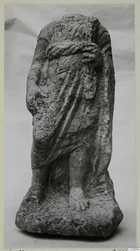 Stone statue of a standing draped figure from Soli, with the head and upper body worn away