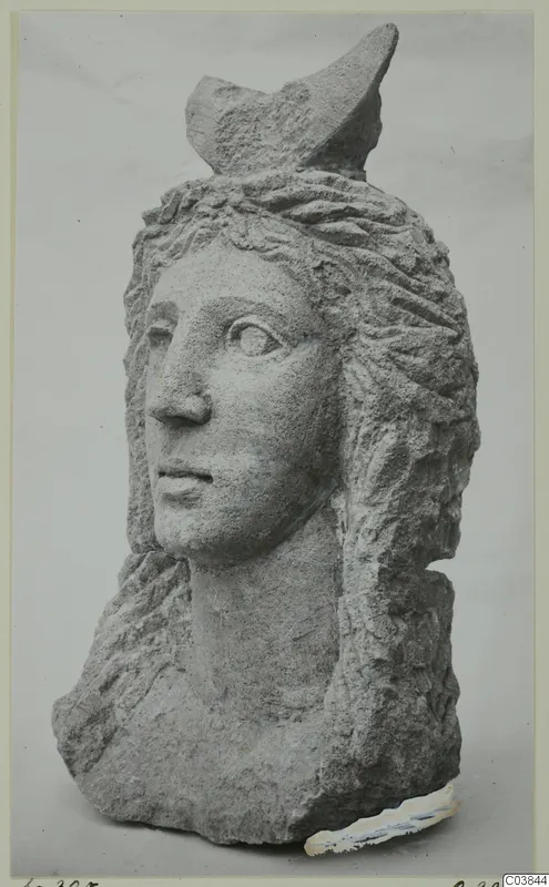 Carved stone head with a wavy hairstyle and a broken projection on top, from Soli