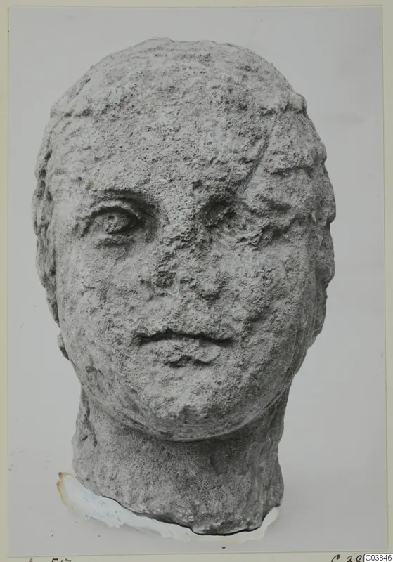 Stone head from Soli, a carved human face with a rough, weathered surface, shown from the front.