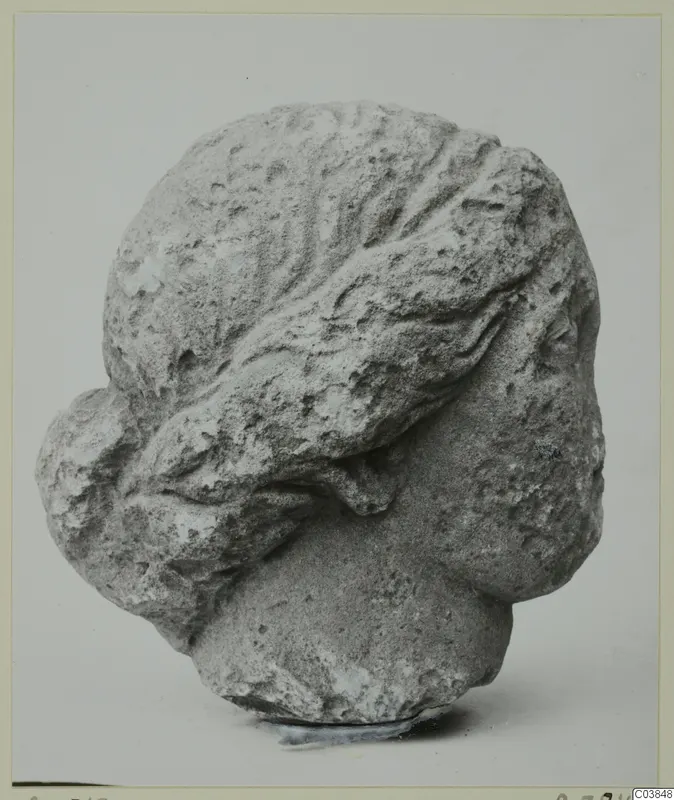 Carved stone head with wavy hair swept back, from Soli
