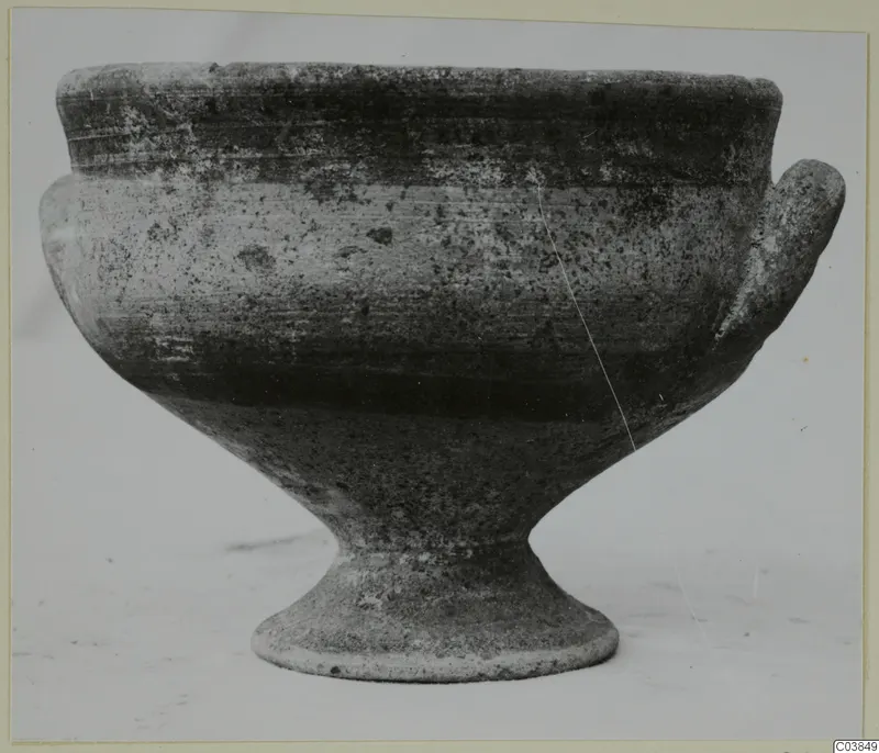 Pottery White Painted III-1, a stemmed bowl with two handles, photographed from the side against a pale background
