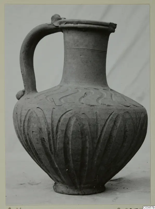 Hellenistic Wares jug with a strap handle, wavy pattern on the shoulder and vertical grooves on the body