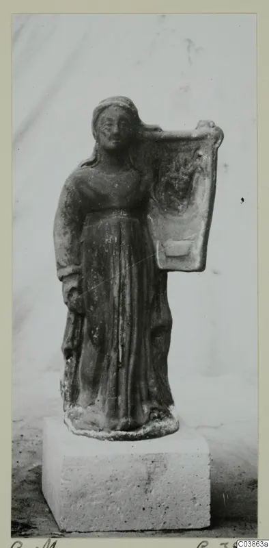 Terracotta figurine of a standing female figure holding a tall flat panel on her shoulder, set on a stone block