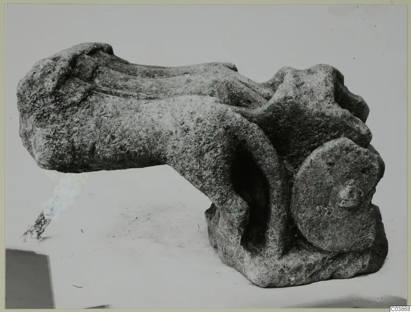 Limestone sculpture fragment from Mersinaki with a long curved body and a rounded head with a projecting nose.