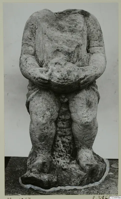 Headless stone sculpture of a seated figure with hands clasped over the lap, from Mersinaki.
