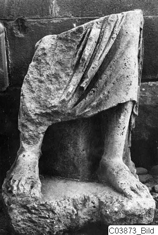 Limestone statue fragment of a draped figure, showing legs and feet on a base, from Mersinaki