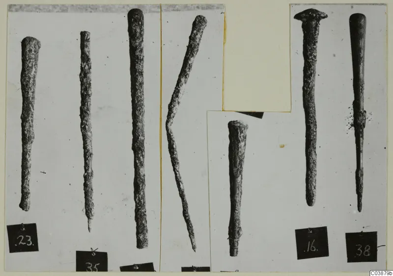 Seven corroded bronze tools, long rods tapering to points, shown in separate photographs on a mounted card