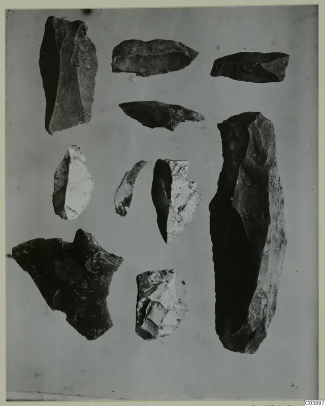 Flaked stone tools and fragments from Kythrea, laid out together on a grey background.