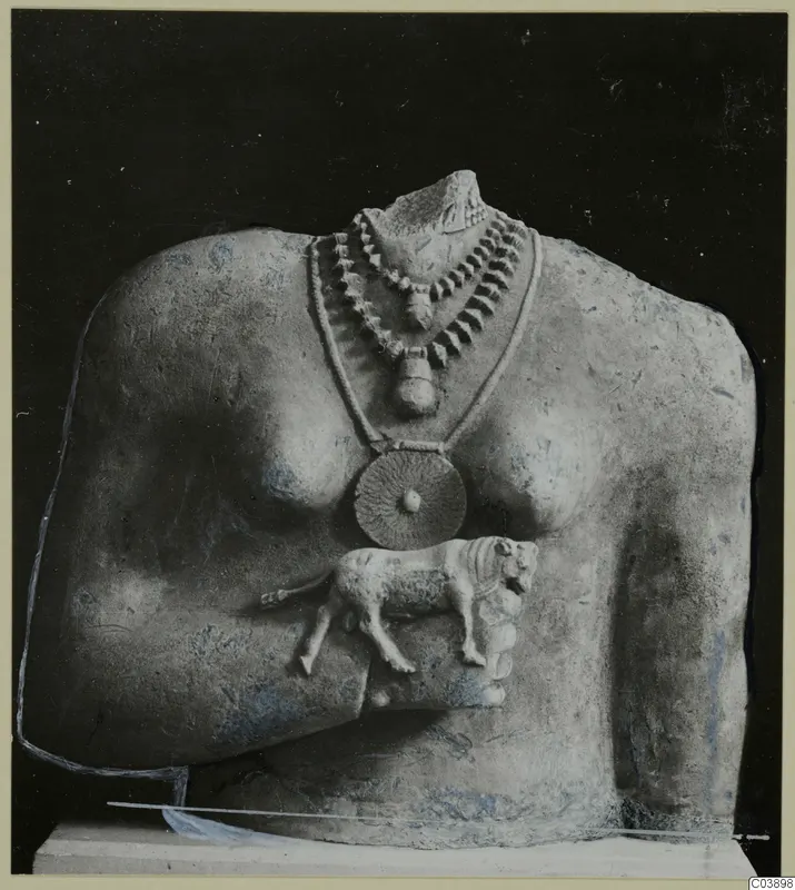 Limestone sculpture of a torso with a layered necklace, a disc pendant and a small carved animal on its side