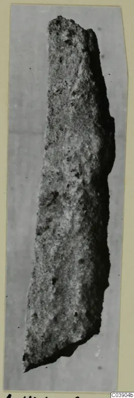 Long, narrow corroded iron object from Amathus tombs, shown on a mounted photograph card
