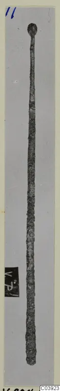 Long thin bronze pin with a knob-shaped head, photographed on a grey card