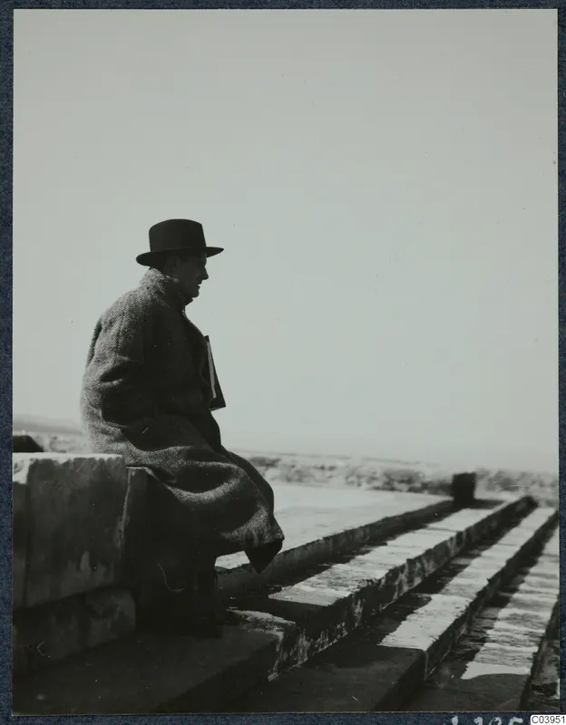 Gjerstad seated on the grand staircase at the palace at Vouni, looking out over the landscape