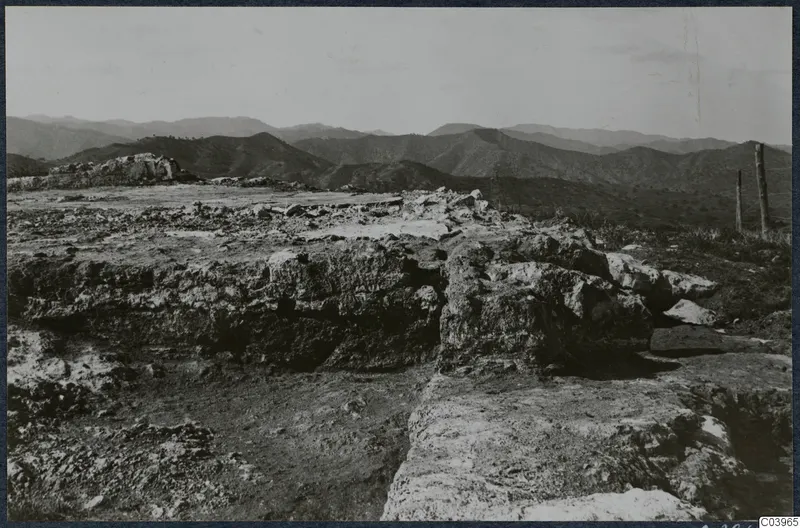 Vouni Temple of Athena: rough stone foundations on a hilltop, with a fence and hills stretching into the distance.